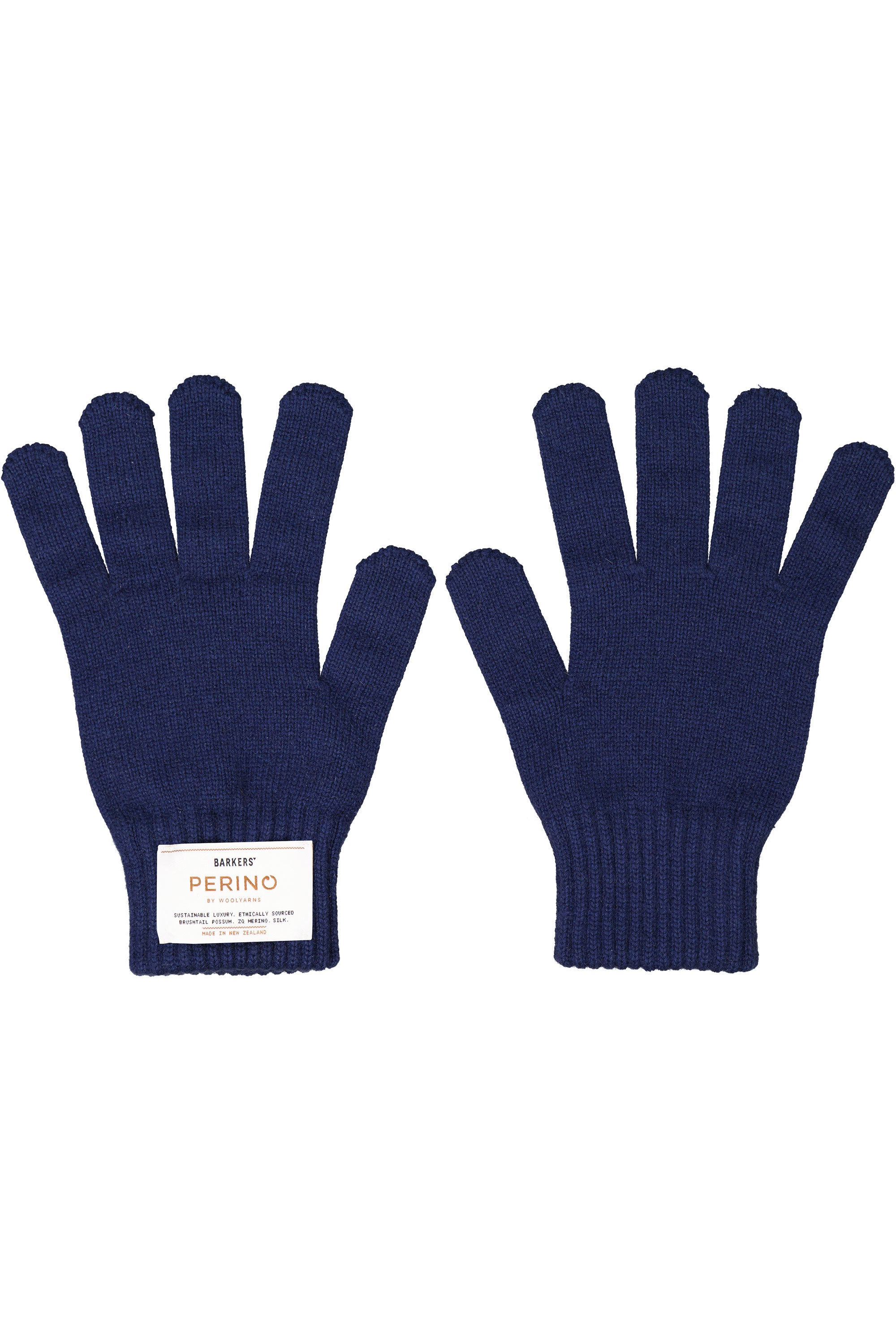 The Mount Aspiring Perino Glove by Woolyarns Perino is a navy blue knit glove with ribbed cuffs, made from luxurious New Zealand merino. One glove has a white rectangular label with text near the wrist and is displayed palm up.