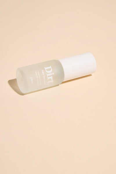 A frosted glass bottle labeled "Carry On Stain Remover" by Other rests on a beige surface. This minimalist spot stain treater has a white cap, holds 120 ml, and is perfect for tackling tough stains in style.