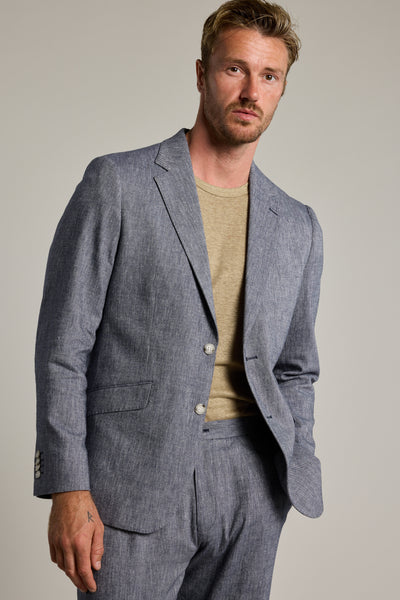 A man with light brown hair and facial hair wears the Barkers Paden Twill Blazer in light gray over a beige t-shirt, standing against a plain light background and looking directly at the camera with a neutral expression.