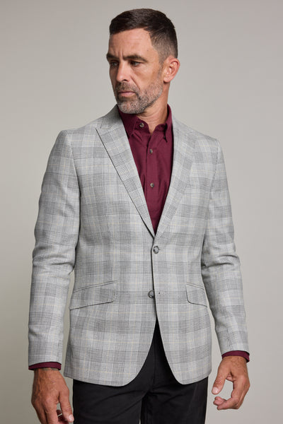 A man with short dark hair and a beard wears the Barkers Remsen Check Blazer over a burgundy shirt, standing against a plain light background and gazing to his left.