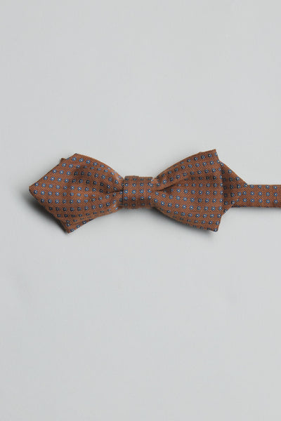 The Parisian Mitre Geo Bow Tie by Parisian features a brown base with a small repeating blue and white geometric pattern, handmade in New Zealand and shown against a plain light background.