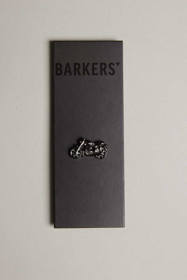 A black Barkers card displays the Motorbike Lapel Pin in gunmetal, shown vertically against a light gray background.