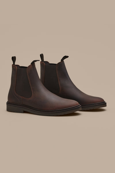 The Johnson Chelsea Boot by Barkers is a classic brown leather men's boot with black elastic side panels and pull tabs, shown on a light beige background—an essential addition to any footwear collection.