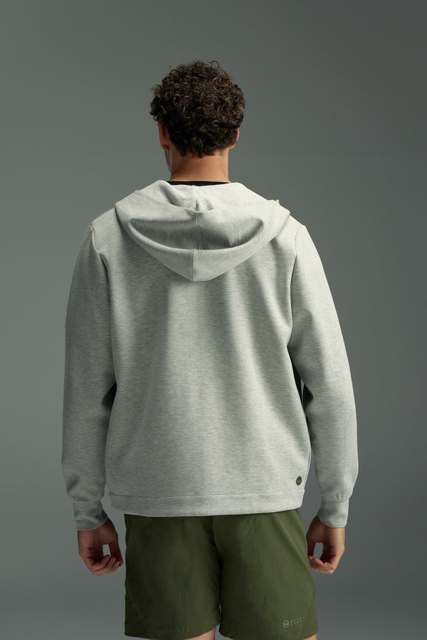 A person with short curly hair, seen from behind, wears the WearEver Altitude Hoody by WearEver in light gray and olive green shorts, standing against a plain gray background.