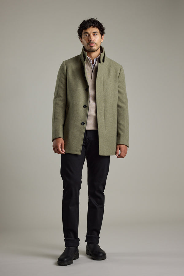 Man wearing a Barkers Raymond Coat, beige sweater, black pants, and black boots, standing.