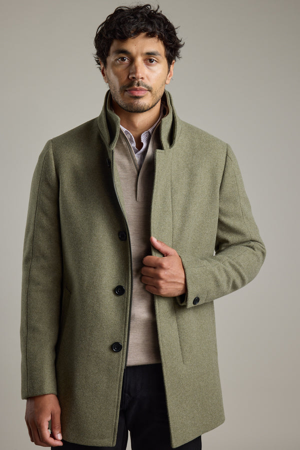 Man wears Barkers Raymond Coat over a beige sweater against a plain background.