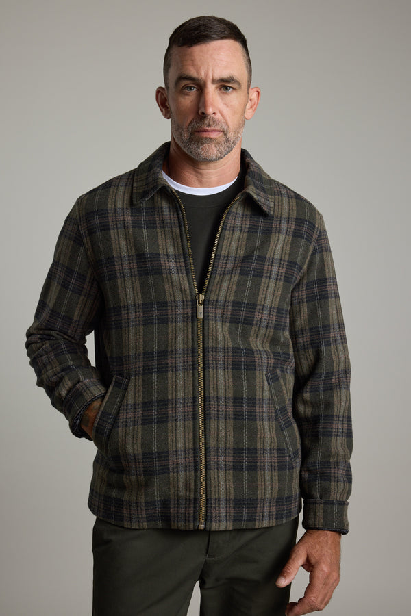 Man wearing a Barkers Zermatt Wool Jacket, dark pants, and a white t-shirt.