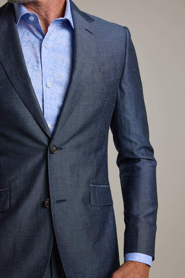 A man wears the Barkers Charles Texture Suit Jacket over a light blue, patterned dress shirt. The image highlights the modern tailoring and unbuttoned top of the jacket, showing his torso and part of his left arm.