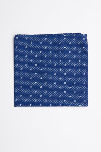 The Randolph Ditsy Flower Pocket Square by Barkers is a folded blue cotton accessory featuring a small white geometric pattern, shown on a plain white background.