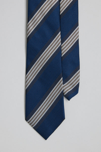 A close-up of the Barkers Potter Stripe Tie, a blue silk tie with classic gray, white, and black stripes, shown on a plain light gray background.