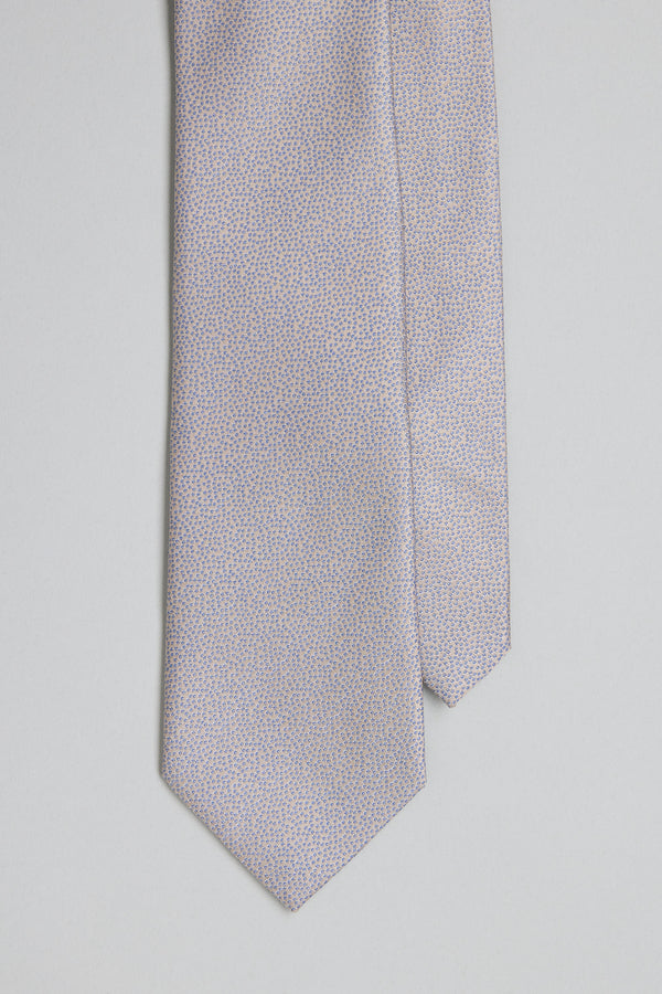 A close-up of the Barkers Empire Texture Tie, a light silk accessory featuring a subtle blue dot jacquard on a pale background—ideal for elevating business attire, shown against a neutral surface.