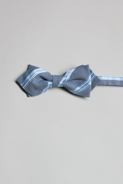 The Parisian Stripe Bow Tie by Parisian features blue with white and light blue diagonal stripes. Expertly handmade in New Zealand, it’s shown on a plain light grey background.