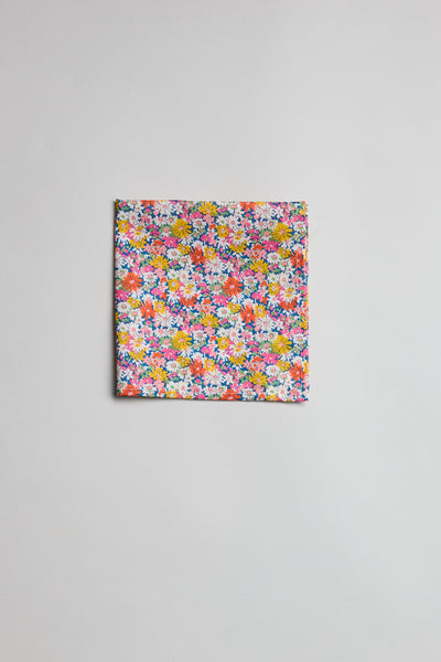 The Liberty Libby PS by Liberty is a pocket square crafted from Tana Lawn cotton, showcasing a vibrant floral pattern with yellow, pink, purple, and white small flowers on a light gray background.