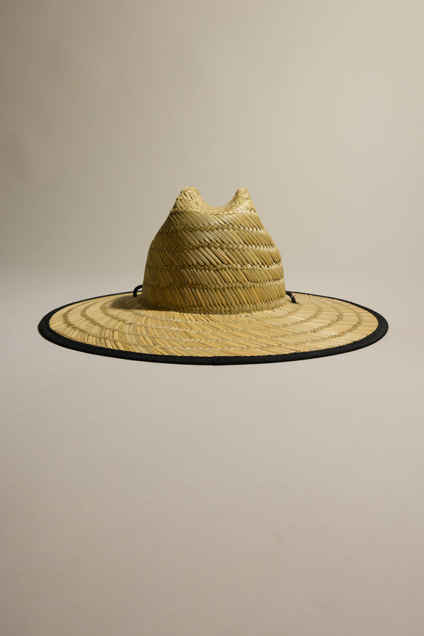 The Barkers Straw Hat by Barkers features a natural woven design and black trim, providing stylish sun protection. Shown on a plain beige background, it’s the perfect summer essential.