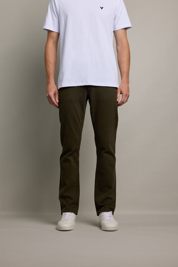 Man in white tee and Barkers Wanderer Straight Coloured Jean stands against a plain background.