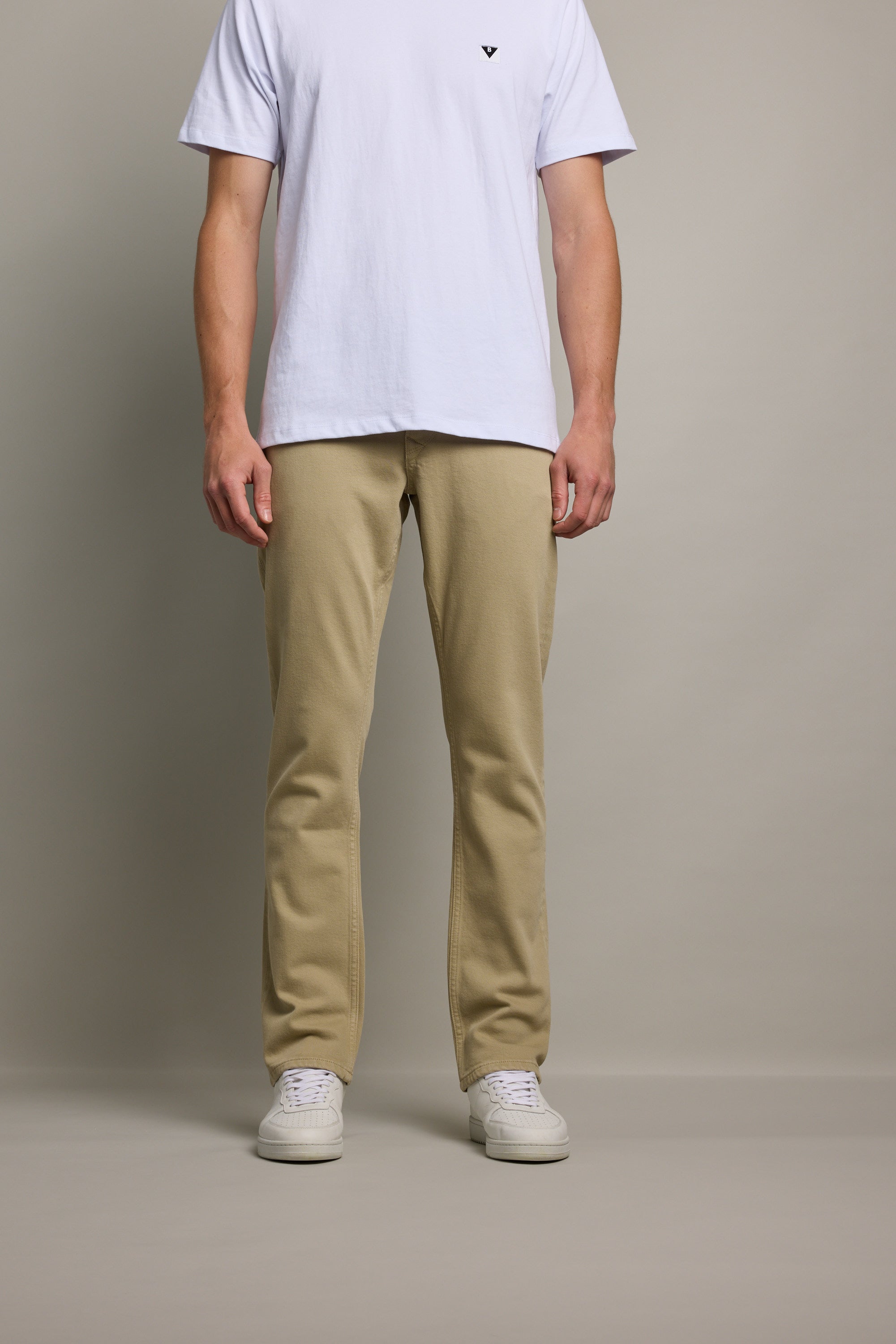 A man in a white t-shirt and Barkers Wanderer Straight Coloured Jean stands against a plain background.