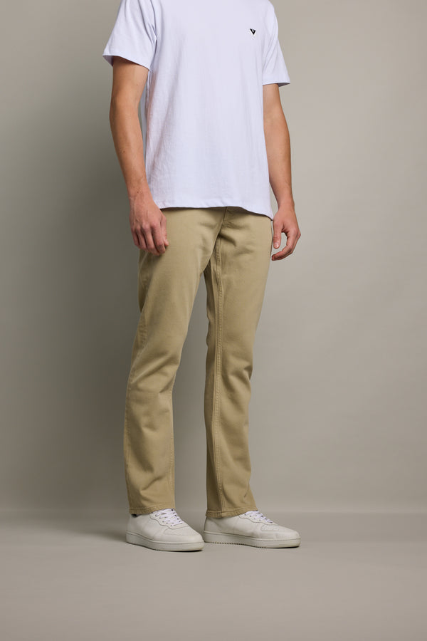 Man in Barkers Wanderer Straight Coloured Jean stands against a gray background.