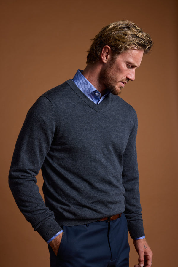 Man in Barkers Skyland ZQrx Merino Vee sweater, looking down against a brown background.