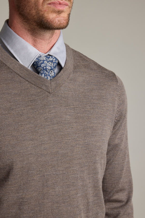 Man wearing Barkers Skyland ZQrx Merino Vee sweater, blue shirt, and floral tie, shoulders up.