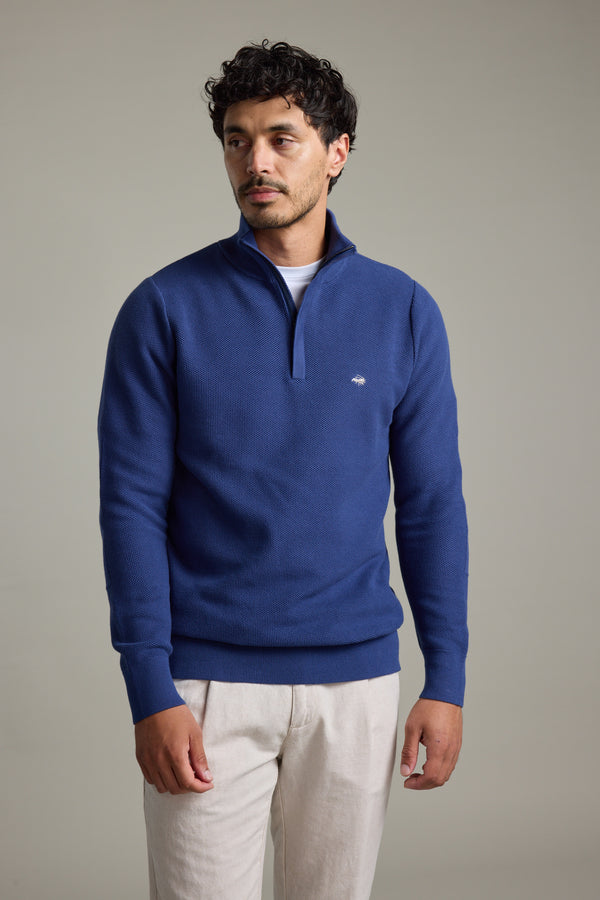 Man wears Barkers Gaston Cotton 1/4 Zip Sweater with light pants against a plain background.
