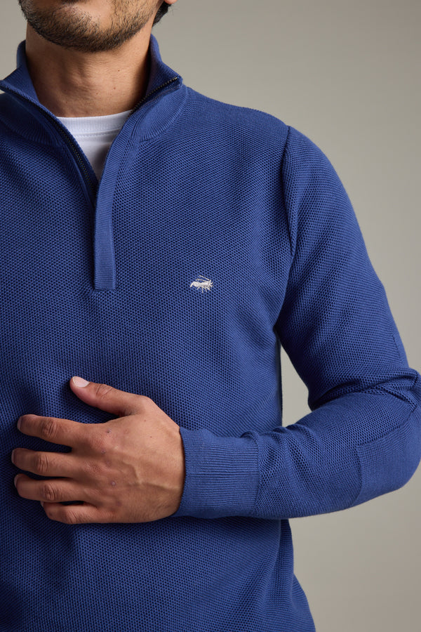 A man in a blue Barkers Gaston Cotton 1/4 Zip Sweater, hand on stomach.