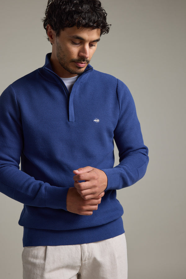 Man wearing Barkers Gaston Cotton 1/4 Zip Sweater in blue, adjusting his sleeve.