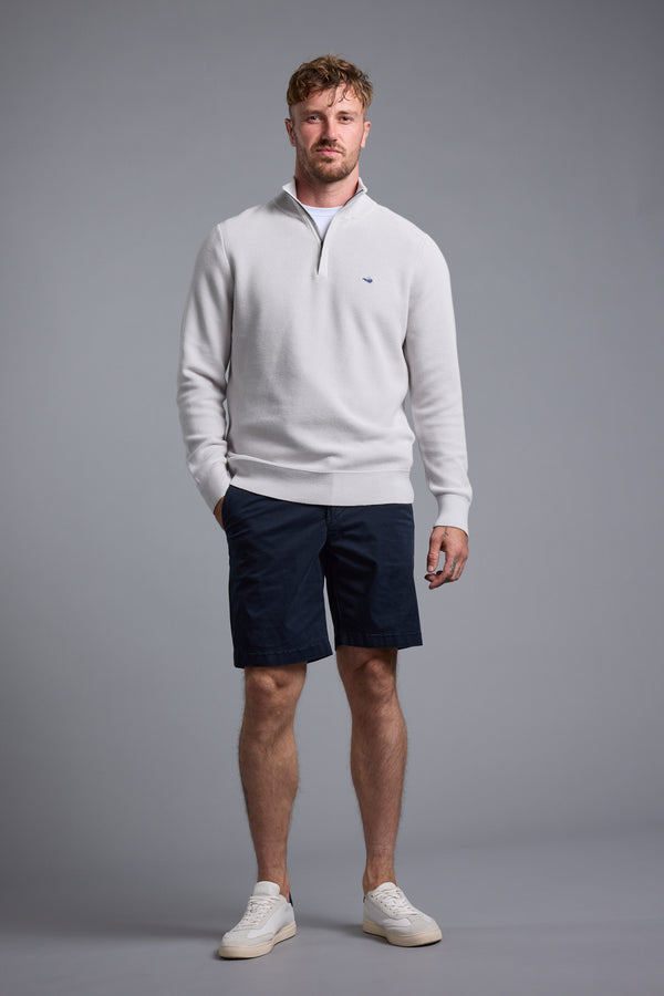 Man wearing the Barkers Gaston Cotton 1/4 Zip Sweater and navy shorts, on a gray background.