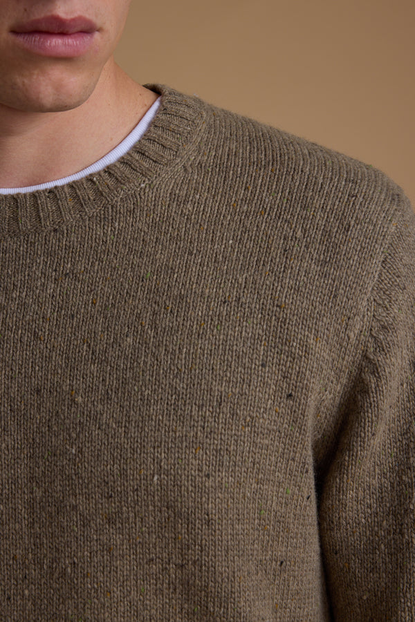 Close-up of a person wearing the Barkers Anglers Merino Crew sweater over a white crew-neck shirt. Only the lower half of the face, neck, and upper torso are seen against a plain beige background—a cozy winter staple look.