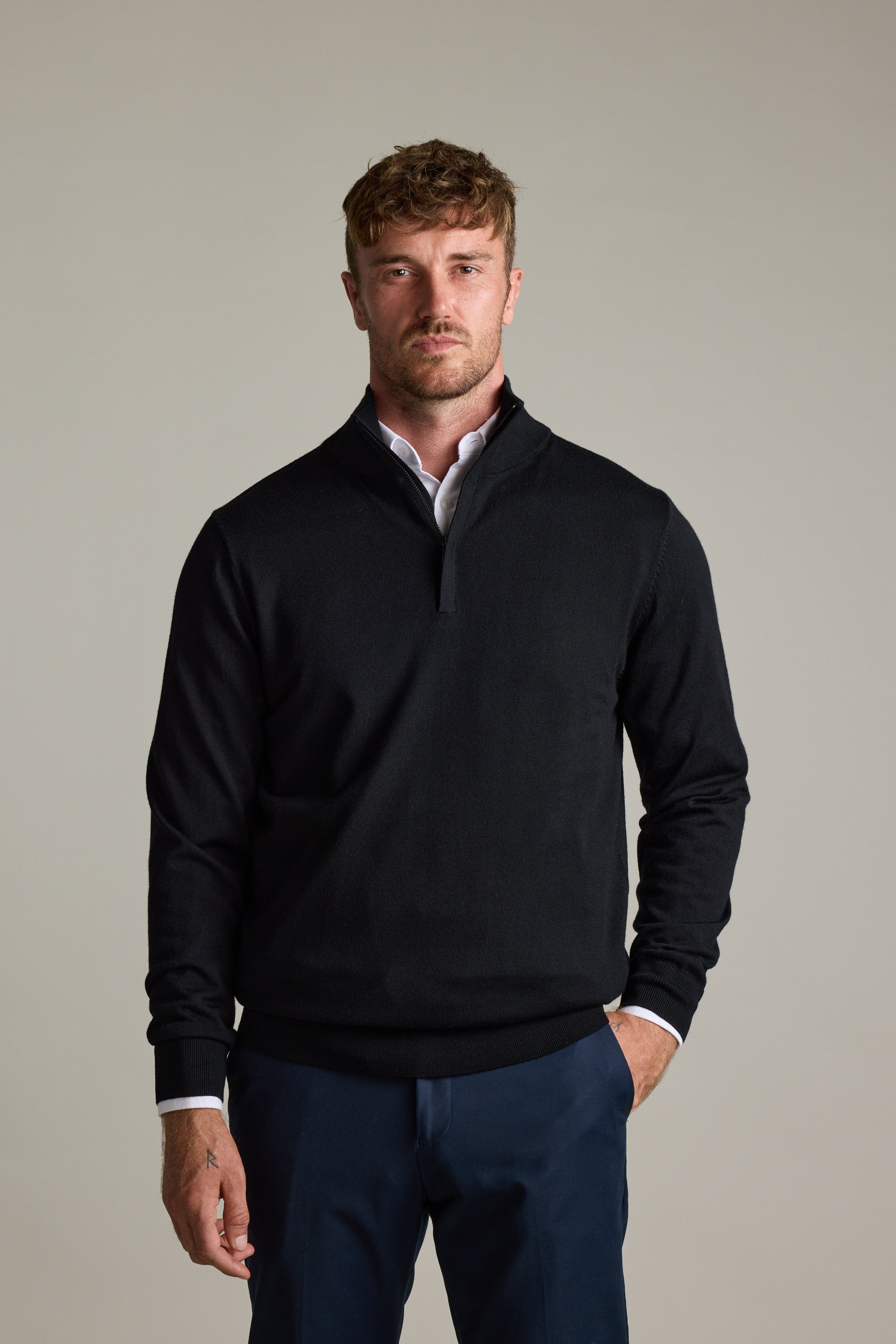 Man wearing Barkers Skyland ZQRX Merino 1/4 Zip and navy pants stands against a light background.