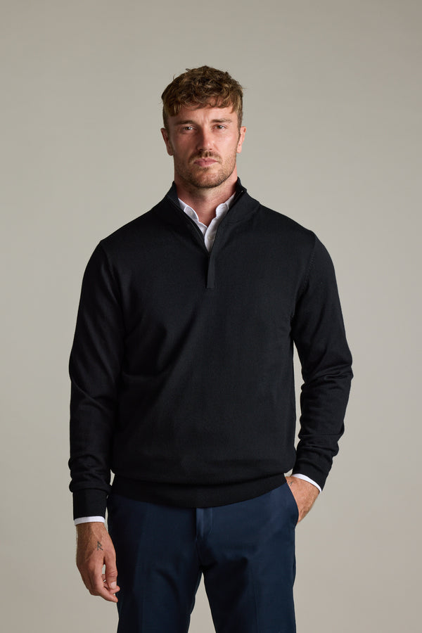 Man wearing Barkers Skyland ZQRX Merino 1/4 Zip and navy pants stands against a light background.