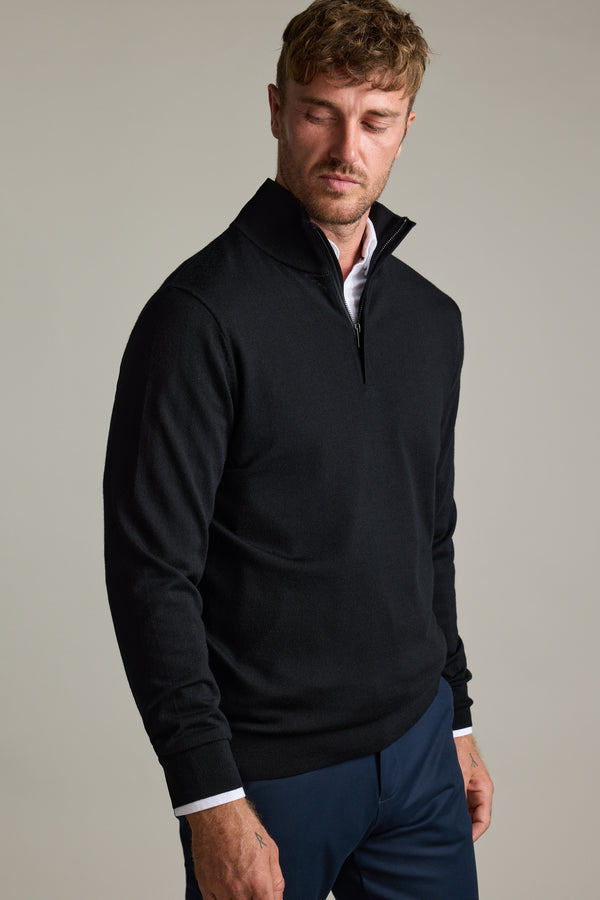 Man in Barkers Skyland ZQRX Merino 1/4 Zip and navy pants, looking down neutrally.