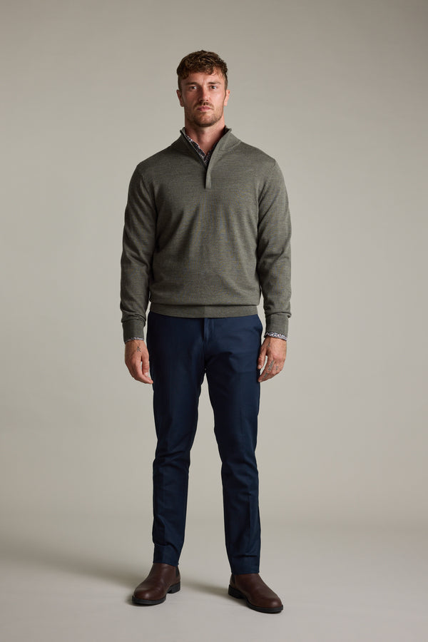 Man wears a gray Barkers Skyland ZQRX Merino 1/4 Zip, navy pants, and brown shoes.