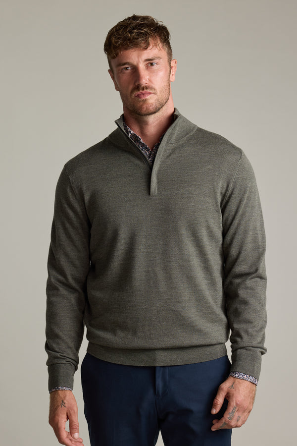 Man wears Barkers Skyland ZQRX Merino 1/4 Zip and navy pants against a plain background.