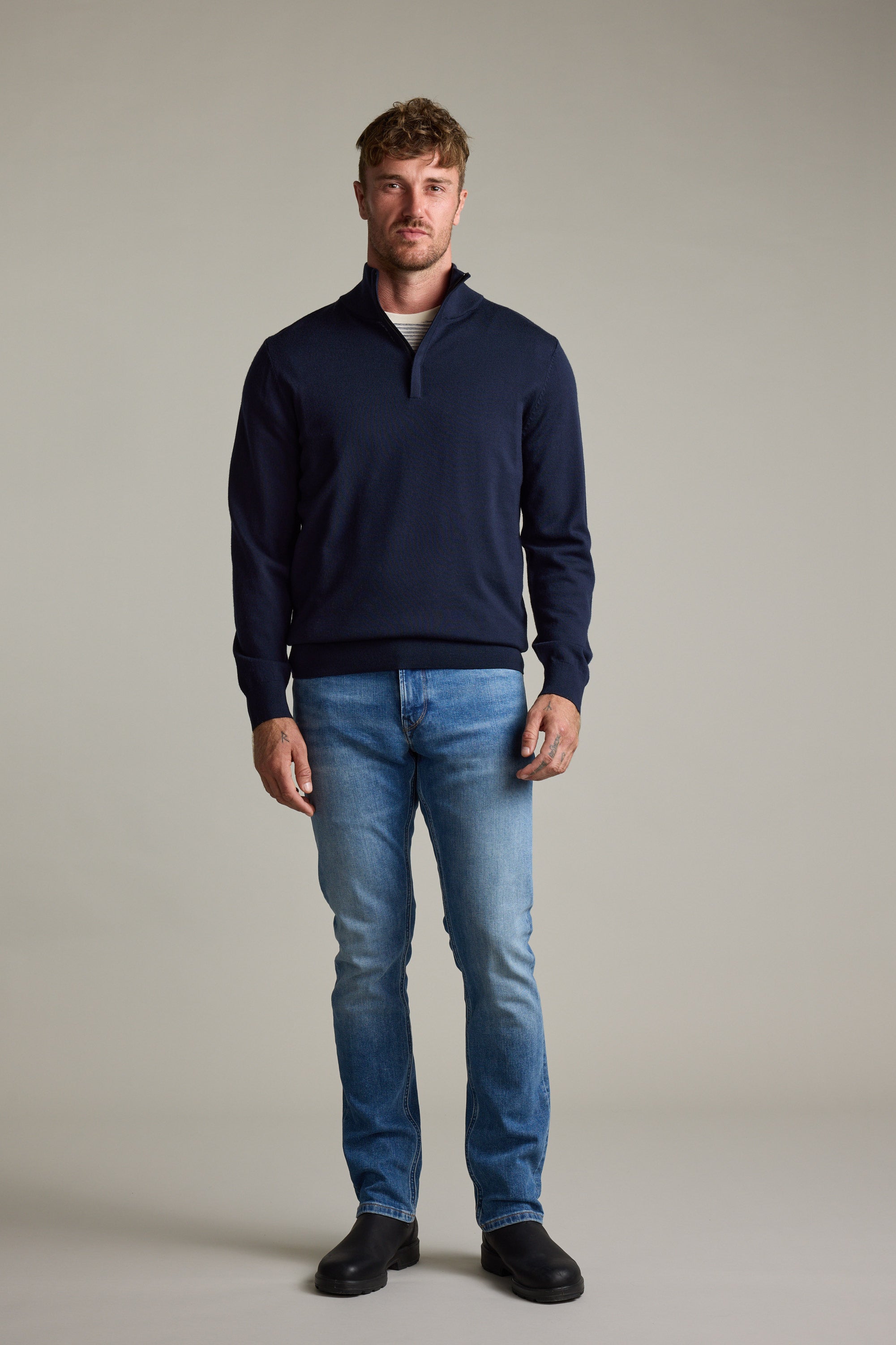 Man in blue jeans, Barkers Skyland ZQRX Merino 1/4 Zip pullover, and black shoes.