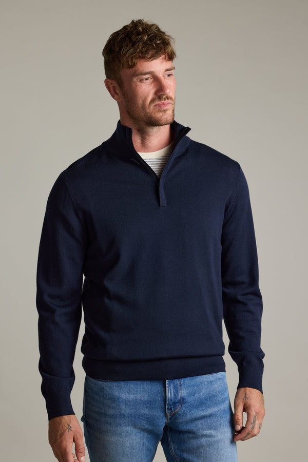 Man in a Barkers Skyland ZQRX Merino 1/4 Zip and blue jeans against a plain background.