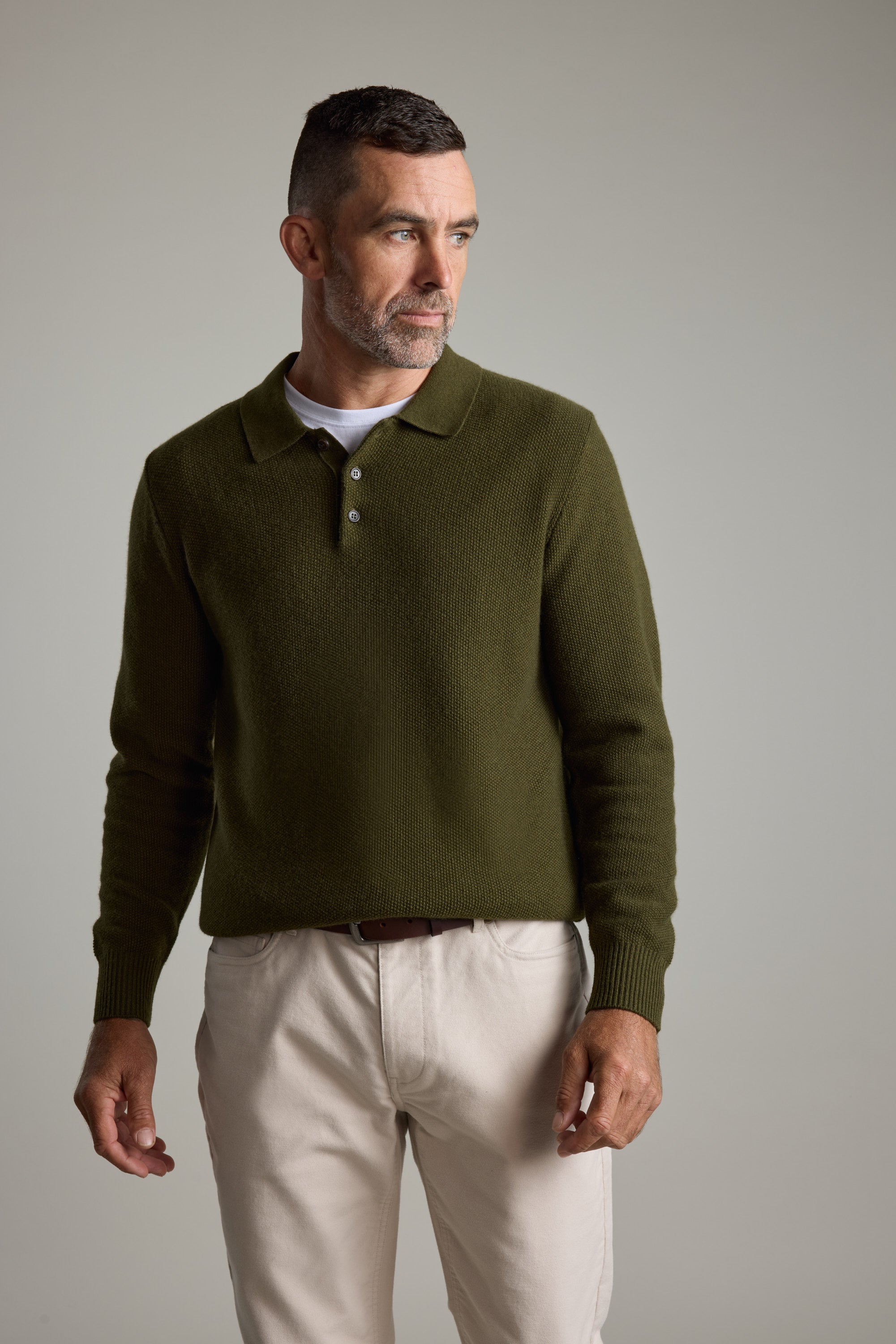 Man in Barkers Ainsley Woollen Long Sleeve Polo and light pants looks to the left.