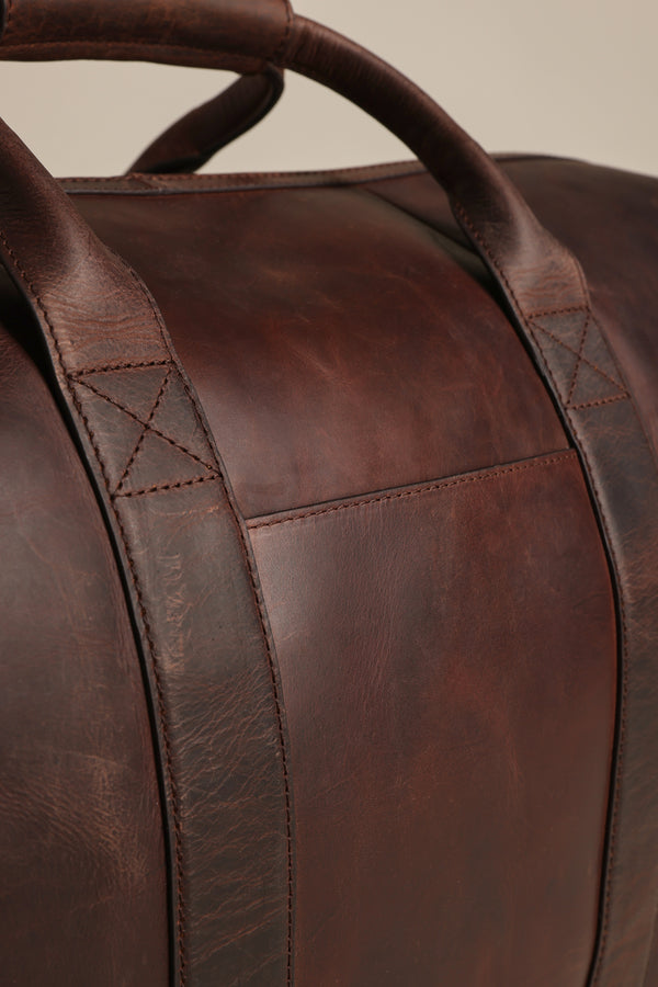 Close-up of the Barkers Costello Leather Weekender, highlighting its detailed handle stitching and smooth, slightly textured premium leather surface.
