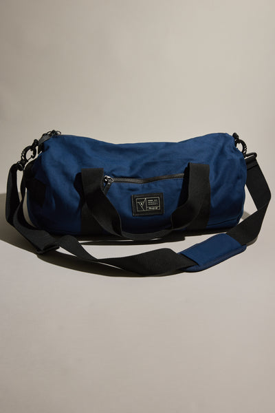 Barkers Canvas Duffle Bag: blue cotton canvas, black straps, front zipper—durable for travel.