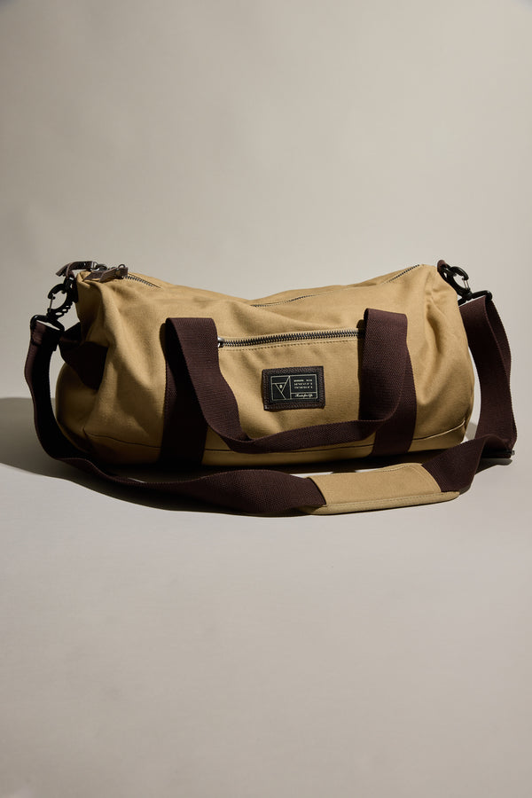 Tan Barkers Canvas Duffle Bag with dark brown straps—a stylish travel companion.