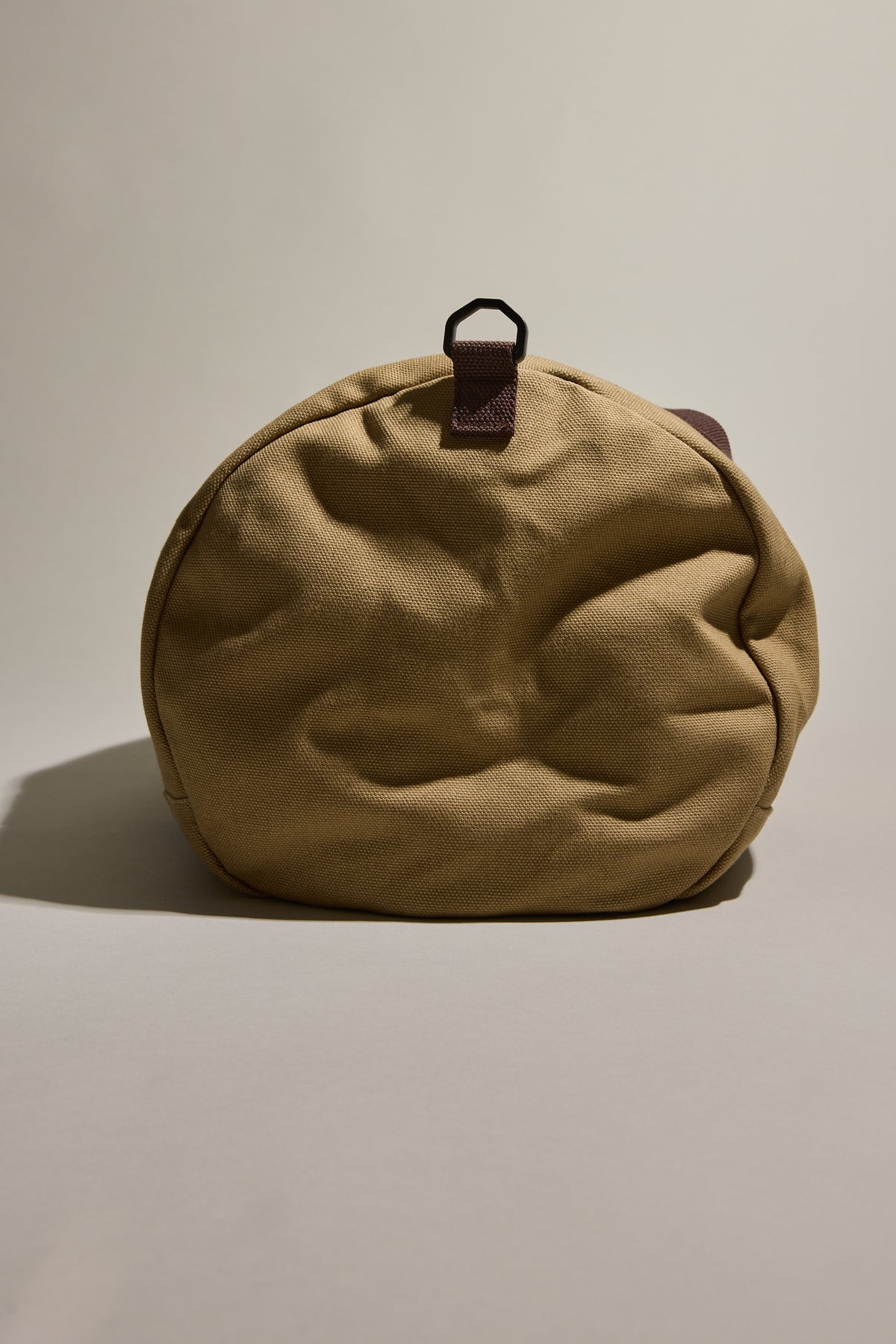 Barkers Canvas Duffle Bag: tan round cotton canvas with brown strap, perfect for travel.