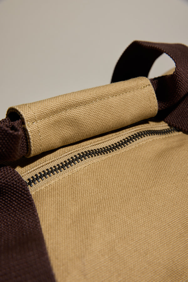 Close-up of a brown zipper on a Barkers Canvas Duffle Bag with dark brown straps.