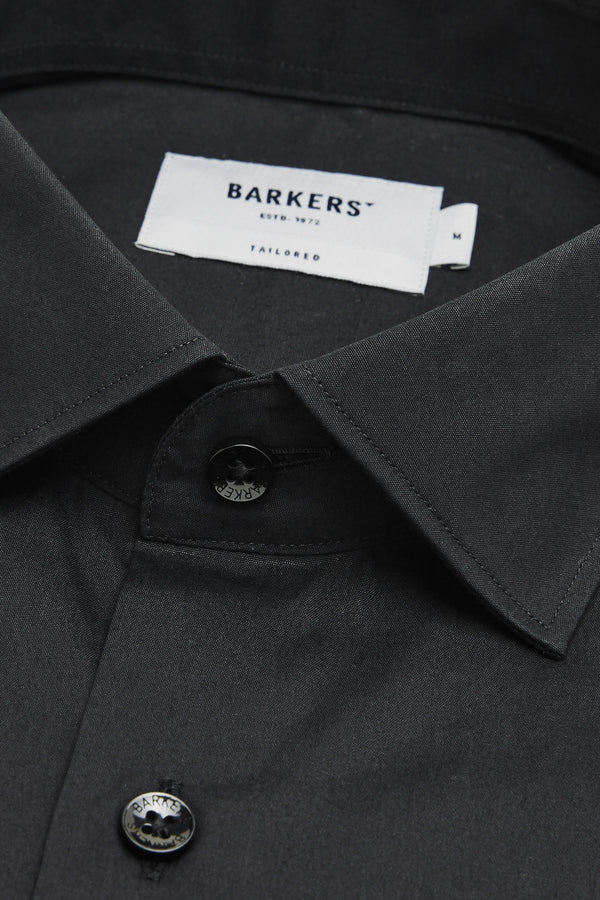 Close-up of a black Barkers Tribeca Reg Cuff Shirt, featuring two visible buttons and a white Barkers label inside the collar. The 100% cotton fabric looks smooth, wrinkle-free, and neatly pressed.