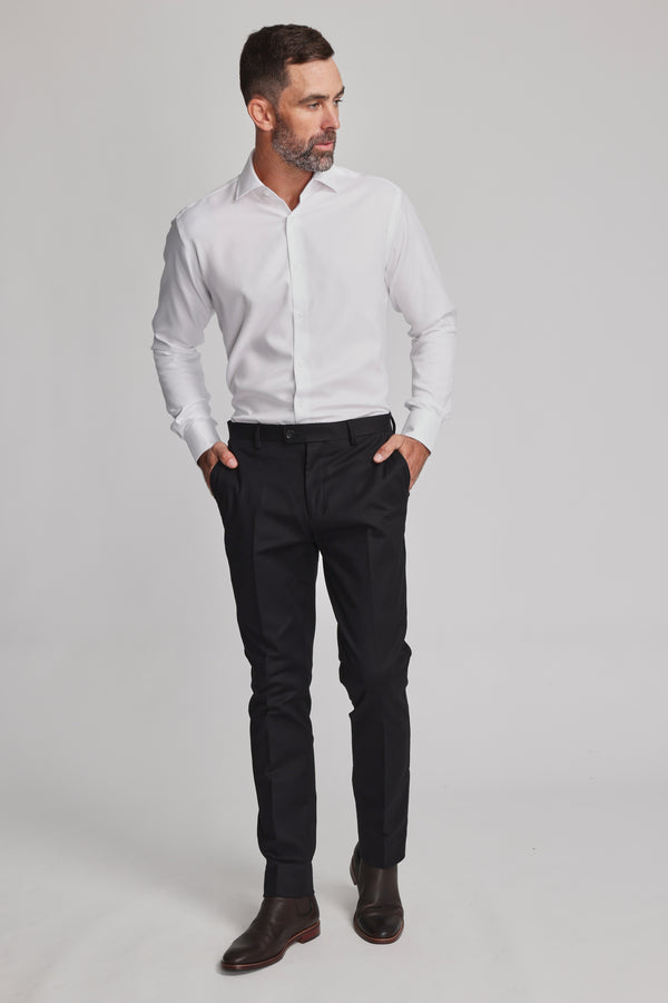 A man with short dark hair and a beard wears the Barkers Mexted Texture Shirt, black dress pants, and dark brown shoes. He stands with hands in his pockets, looking to the side against a plain light background.