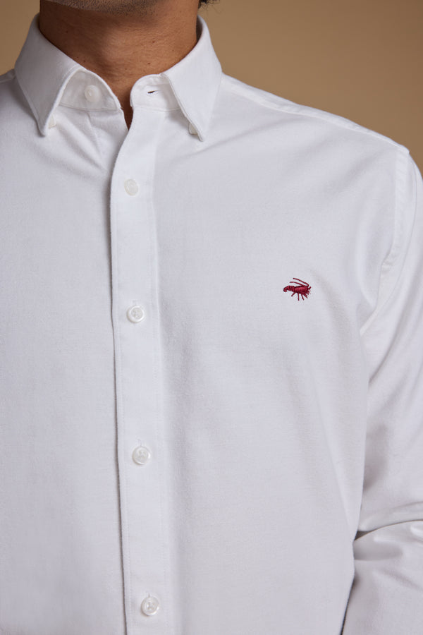 A person wearing the Barkers Maynard Oxford Shirt, made from responsibly sourced cotton with a small red embroidered chest logo, is shown from shoulders to waist against a neutral background.