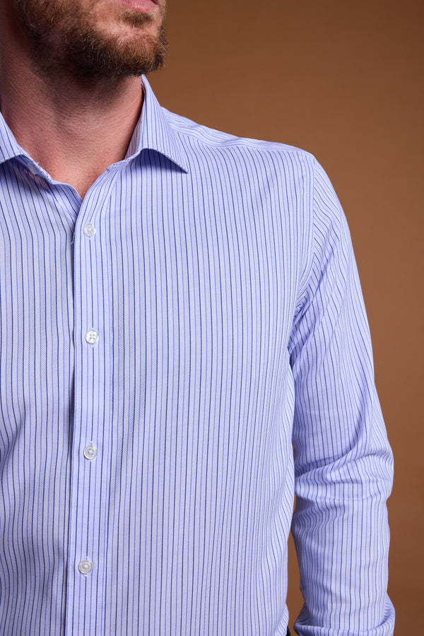 A man stands against a plain brown background wearing the Barkers Asmara French Cuff Business Shirt—a tailored fit, light blue dress shirt with thin dark vertical stripes. His face is partially out of frame.