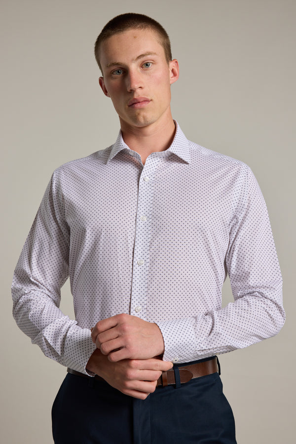 A young man with short hair wears the Barkers Foster Print Business Shirt—a light, wrinkle-free, tailored shirt with a subtle dot pattern—standing against a plain background and looking directly at the camera.