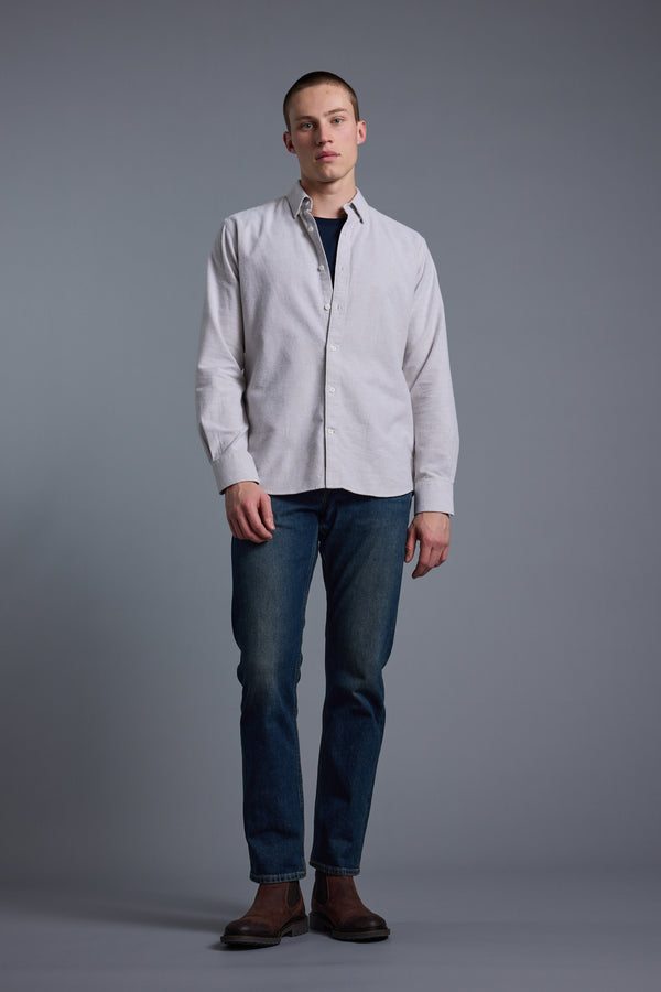 A person stands against a plain gray background wearing the Barkers Maynard Oxford Stripe Shirt over a dark shirt, paired with blue jeans and brown boots, looking directly at the camera with a neutral expression.