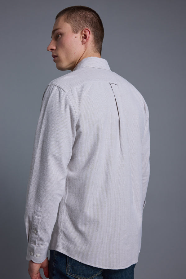 A man with short hair wears a Barkers Maynard Oxford Stripe Shirt and blue jeans, standing with his back to the camera and looking over his left shoulder against a plain grey background.
