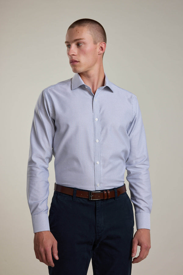 Man in a Barkers Rhea Stripe Business Shirt and dark pants looks left against a plain backdrop.