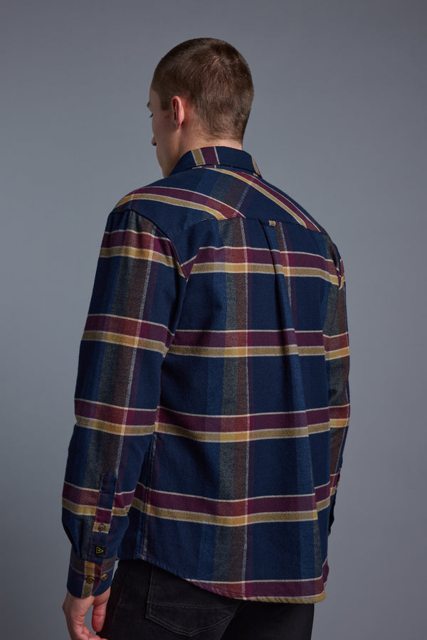 A person with short hair, seen from behind, wears the Barkers Heaton Check Overshirt in vintage dark blue, yellow, and maroon plaid with long sleeves, standing against a plain gray background.